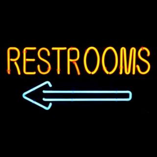 WC Schild Restrooms mit Pfeil nach links. Neon Reklameschild / Hinweis